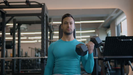 close-up portrait of a french guy on seated alternating dumbbell curls exercise for biceps improving.