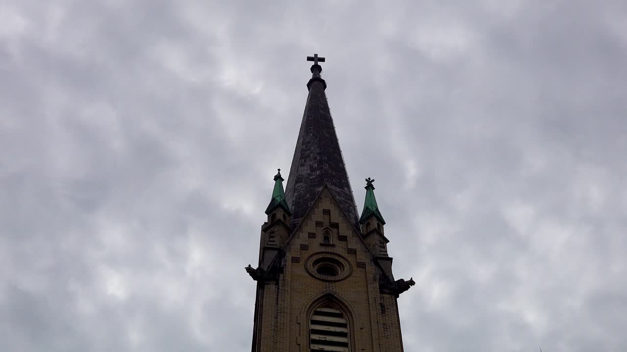 어두운 구름 timelapse에서 고딕 양식의 교회 첨탑