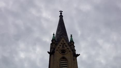 campanario de la iglesia gótica bajo lapso de tiempo de nubes oscuras