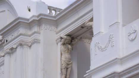 classical sculpture on white building facade