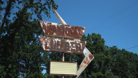 Toma-De-Enfoque-De-Cardán-De-Un-Cartel-De-Almacén-De-Madera-Retro-Oxidado-En-Un-Camino-De-Tierra-Desierto-En-Un-Día-Soleado