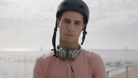 portrait of young handsome man looking confident arms crossed wearing helmet by seaside swimming pool