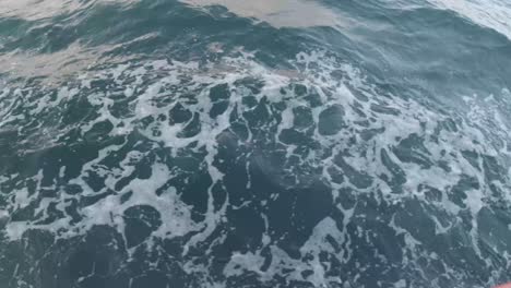 ocean foam near the boat top view, handheld