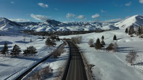Car-Driving-Through-Asphalt-Road-With-Snow-covered-Bald-Mountain-In-Sun-Valley,-Idaho,-USA
