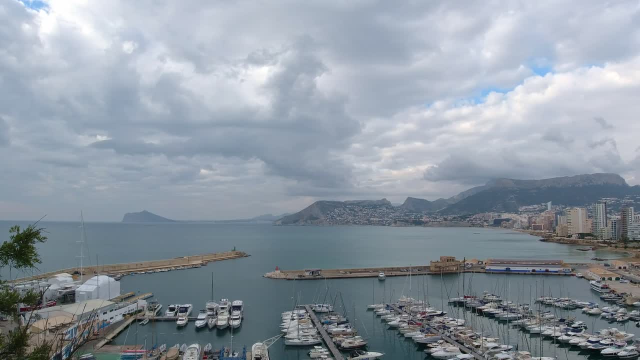 칼페와 어항의 탁 트인 전망, 저녁 구름이 푸른 바다 위로 형성되기 시작합니다.