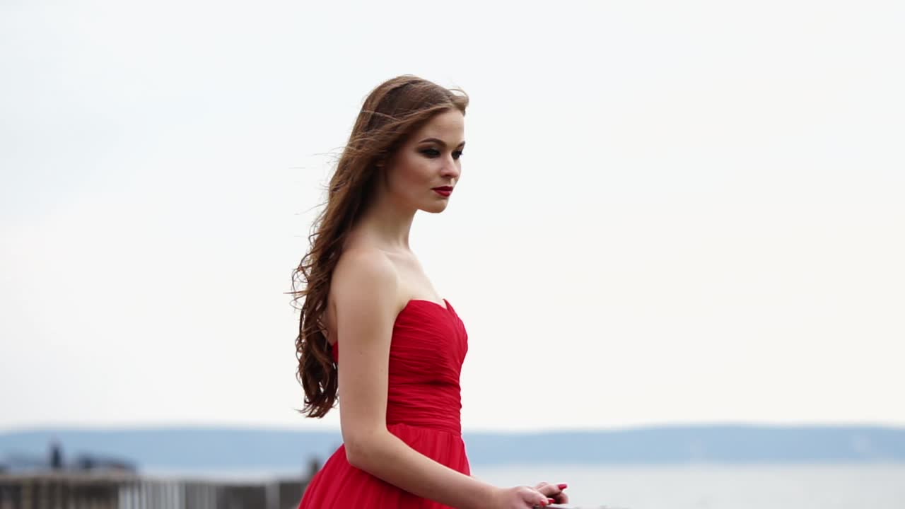 женщина в красном платье у воды