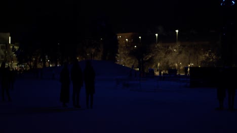 illuminated radio tower adds blue glow to festival goers, winter night