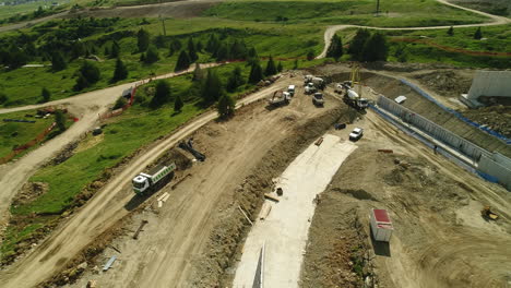 Top-down-aerial-drone-shot-of-a-dam-construction-site-in-the-alpine-mountains