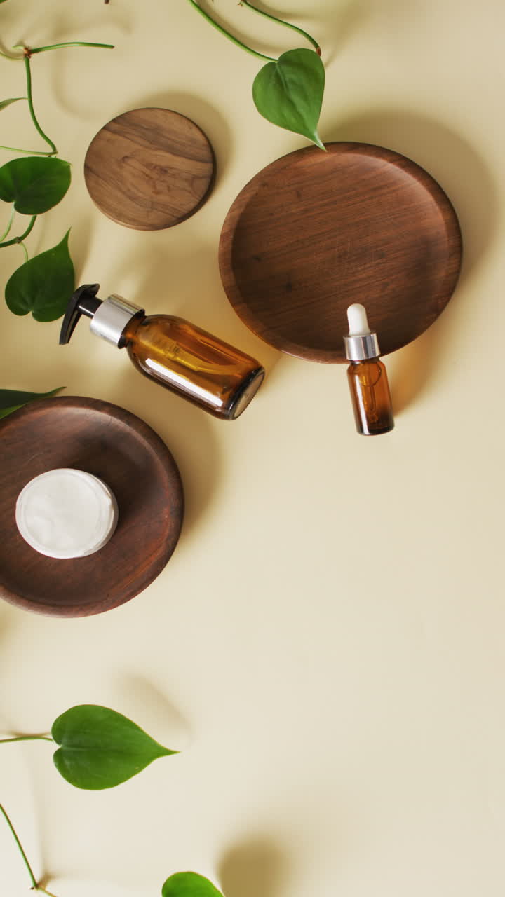 Vertical video of different beauty products with wooden paltes and plants on beige background