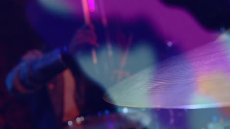 Animation-of-colourful-light-blurs-over-africna-american-man-playing-on-drum-kit-in-slow-motion