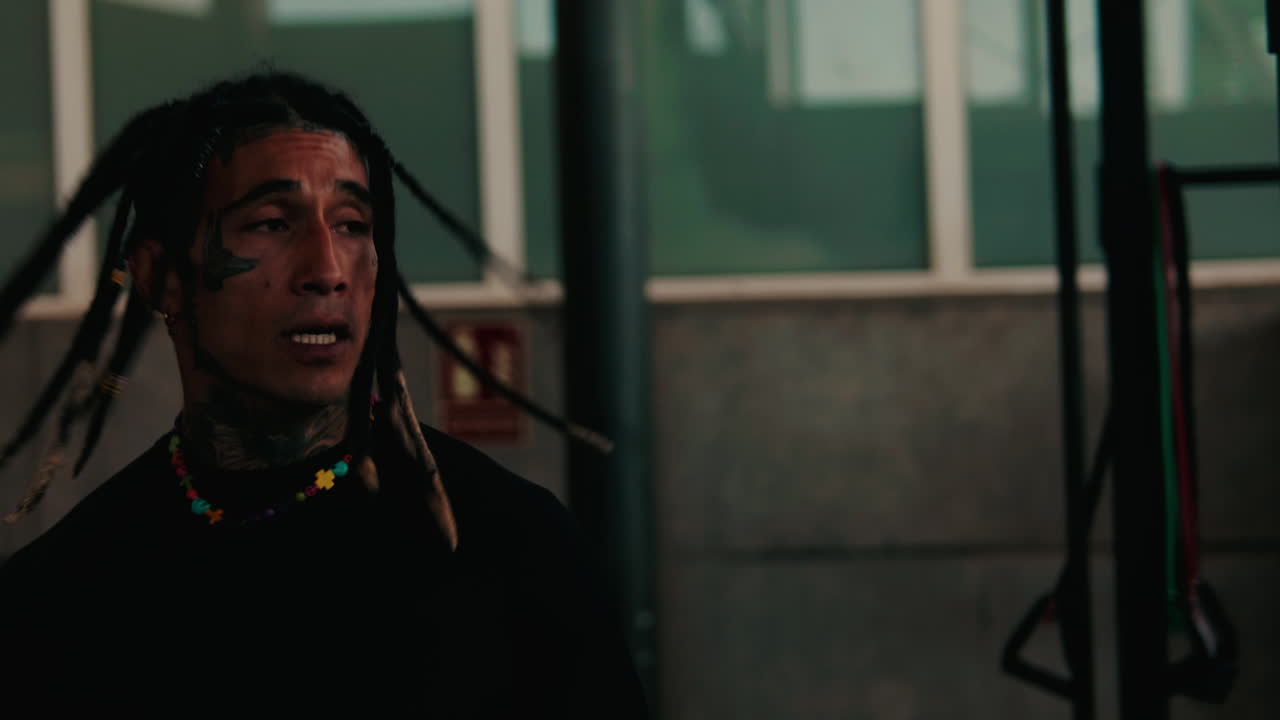 Young Man with Dreadlocks Performing Dynamic Warm-up in Gym