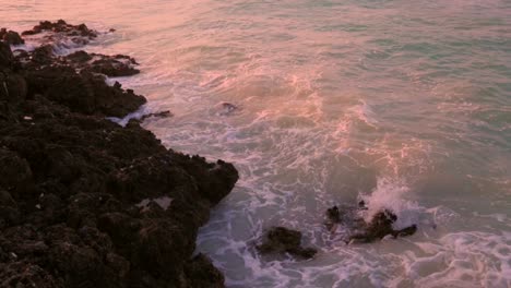 slow motion: waves splashing into rock