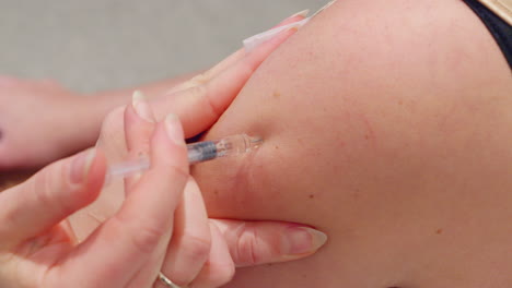 cerca de la aguja que entra en la parte superior del brazo - vacuna inyectada por la enfermera cu