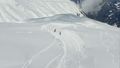 friends skiing on extreme mountains covered in snow, aerial view