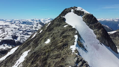 Increíble-Pico-De-Montaña-Revelado-Sobre-Un-Paisaje-Rocoso-Con-Cielo-Azul-Cerca-De-Los-Prados-De-Pemberton-Canadá---Imágenes-Aéreas-De-Drones