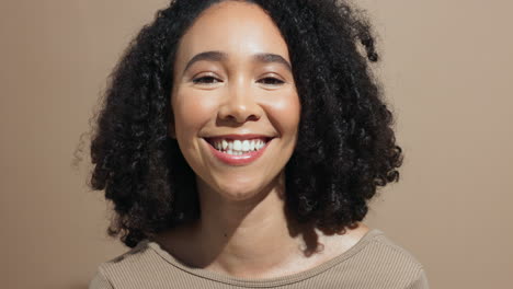retrato de una mujer sonriente con el cabello rizado