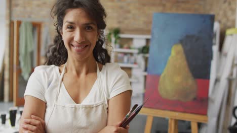 Animation-of-happy-biracial-female-artist-looking-at-camera-in-studio