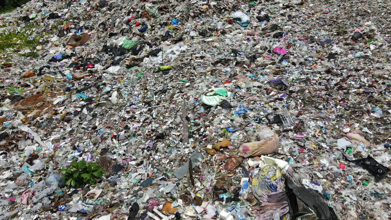 Aerial drone shot of tonnes of plastic pollution and waste at a land fill site in the tropics