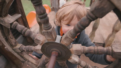 child playing with a pirate ship wheel - imagination playing make believe