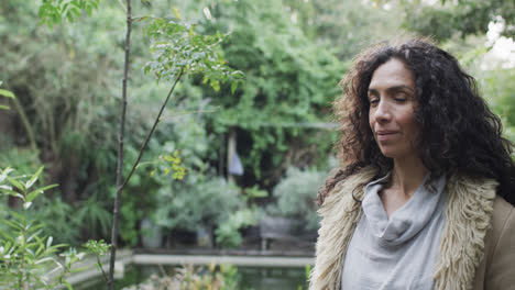 retrato de una feliz mujer biracial en un jardín soleado con espacio de copia, cámara lenta