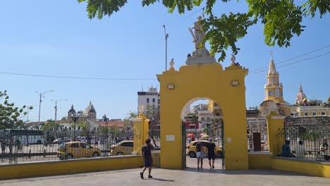 cartagena, colombia. gate on centenario park with old town in background, people and traffic