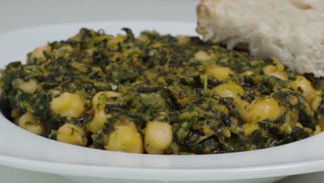 typical spanish dish of garbanzos with spinach, closeup pan left