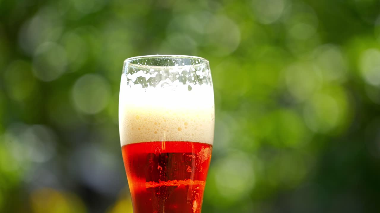 Glass of red beer in a garden