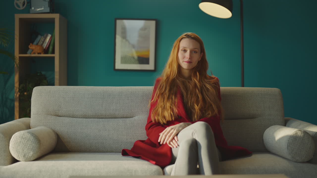 소파에 앉아 있는 세련된 젊은 여성