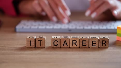 it career concept with wooden blocks and hands on keyboard
