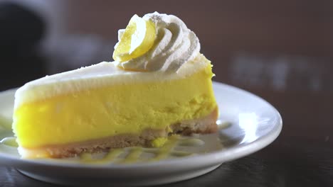 una rebanada de pastel de limón presentada hábilmente en un plato
