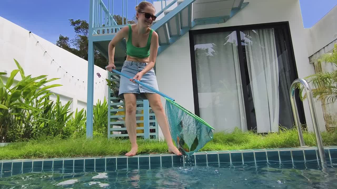 mujer limpiando una piscina con una red
