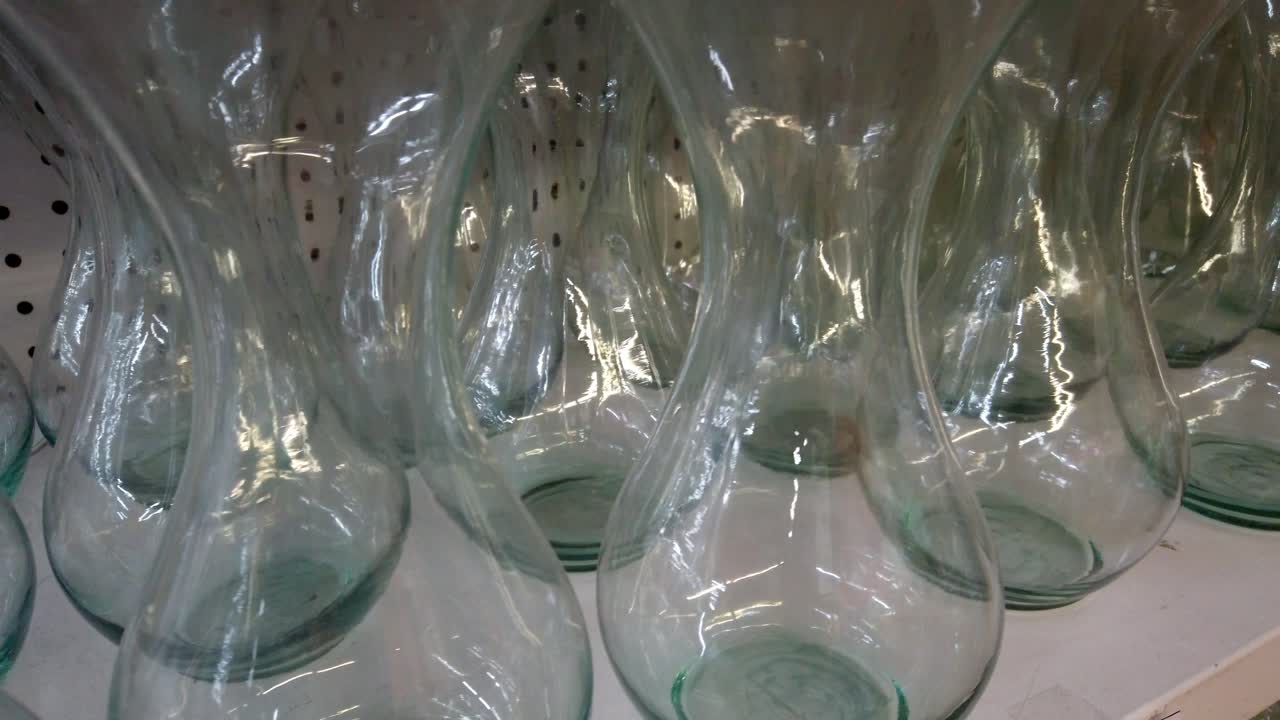 Macro shot of glass vases neatly aligned in a shop aisle with reflective lighting effects