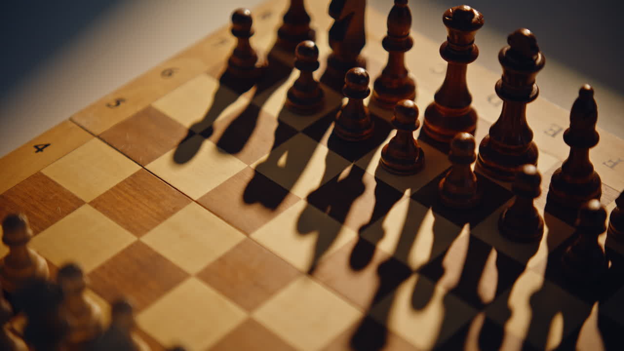 Hand shifting chess pawn on board surface with shadows. Opponent moving item