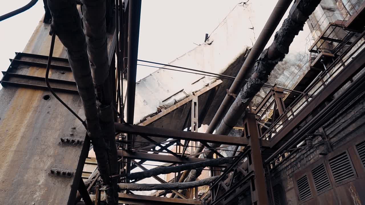 Rusty metal pipes, structures in an abandoned factory. The ruins of a thermal power plant for burning coal