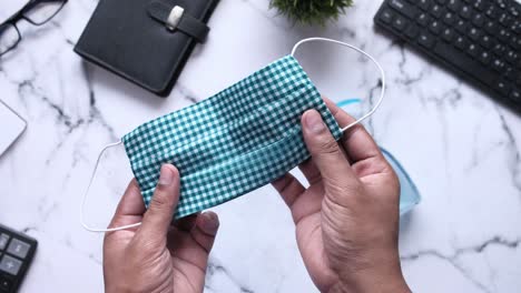 teal plaid cloth mask on a desk