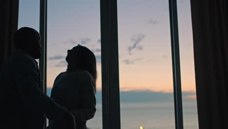 happy young couple dancing in hotel room at sunset enjoying successful vacation having fun celebrating on holiday