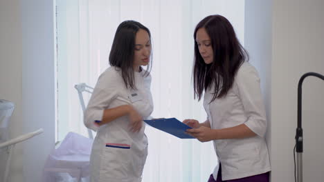 female nurse and doctor talking about medical diagnosis and treatment in the hospital