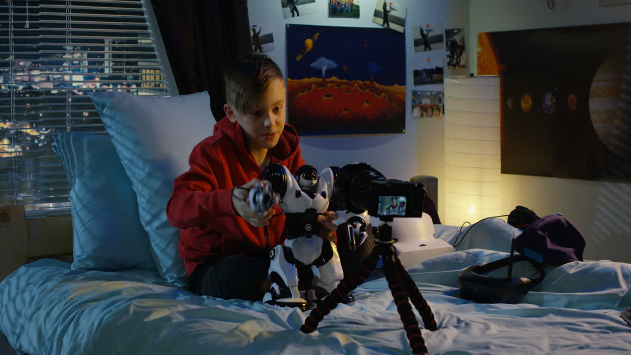 Boy playing with robot toy and camera in his bedroom at night