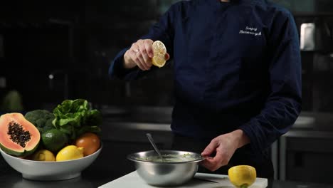 chef preparing a fresh salad with lemon juice