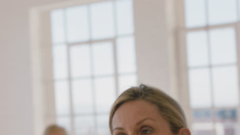 Primer-Plano-Retrato-Hermosa-Mujer-Madura-Haciendo-Ejercicio-En-Clase-De-Yoga-Meditación-Practicando-Pose-De-Guerrero-Disfrutando-De-Entrenamiento-Físico-En-Grupo-En-El-Estudio