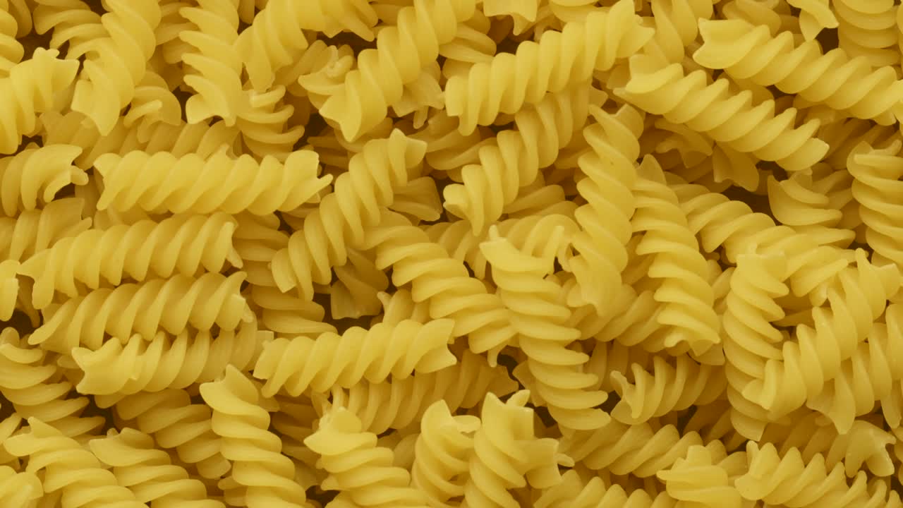 una pila de pasta de fusilli italiano en bruto girando 360 grados