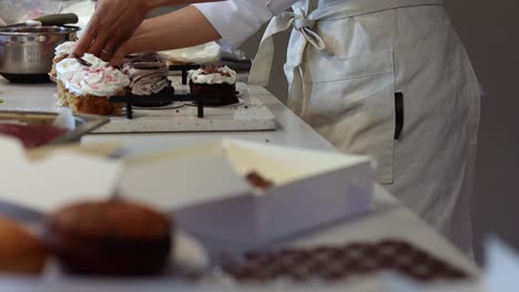 crop baker putting desserts in takeaway paper box