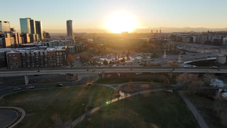 stunning big city aerial shot during golden hour and a huge sunset behind the mountain range