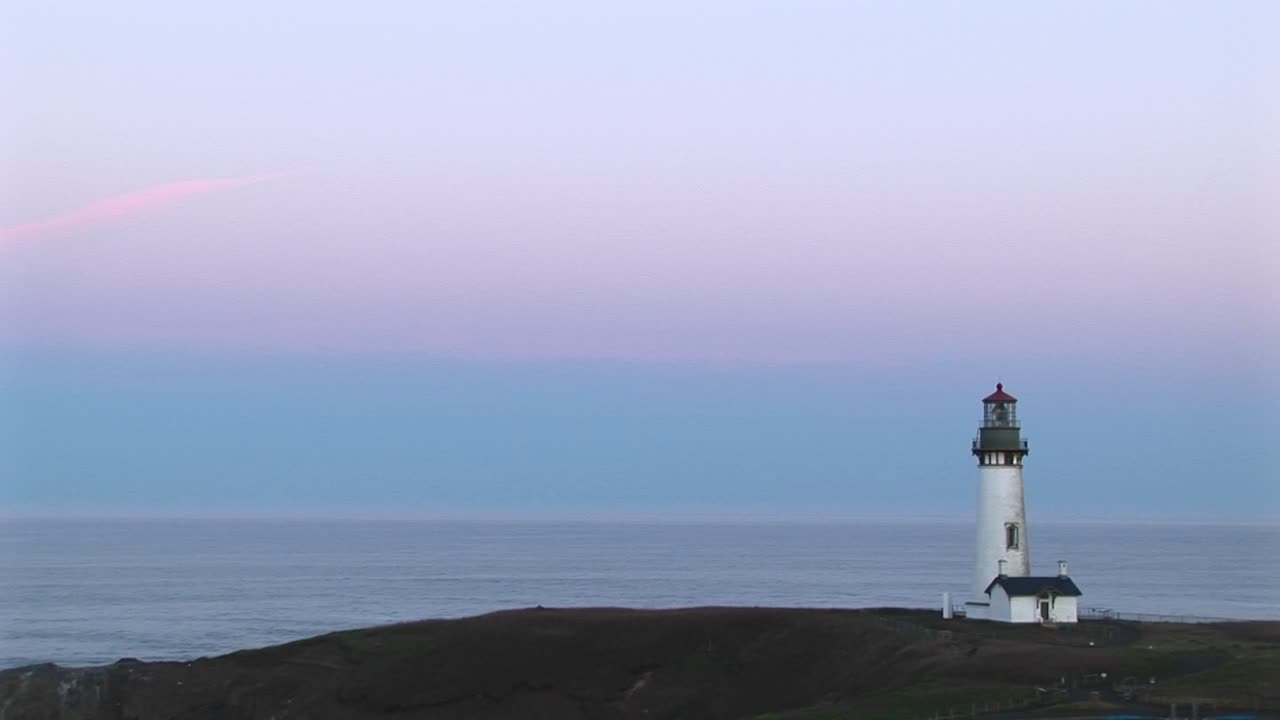 un montaje de tomas largas del faro con un cielo pastel sobre un océano tranquilo