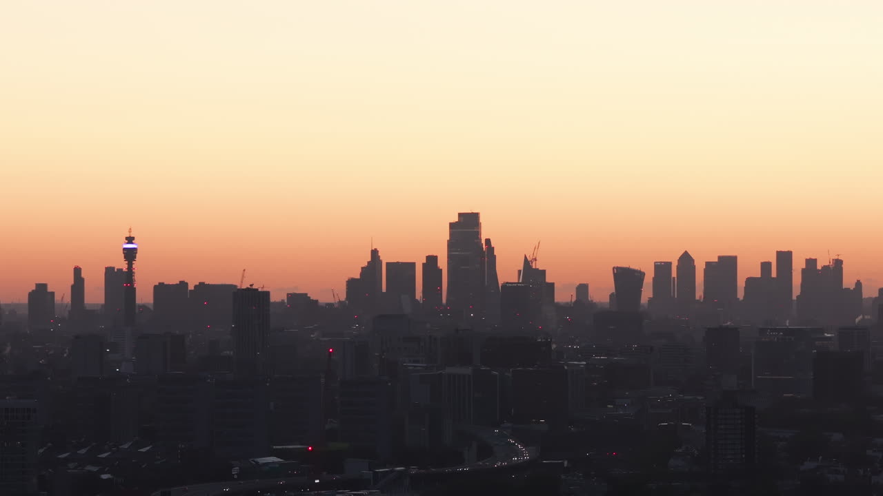 런던 스카이라인의 밀접하게 상승하는 공중 촬영은 새벽의 빛에 대항하여 실루