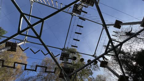 brave people having fun in big wooden structure of adventure park