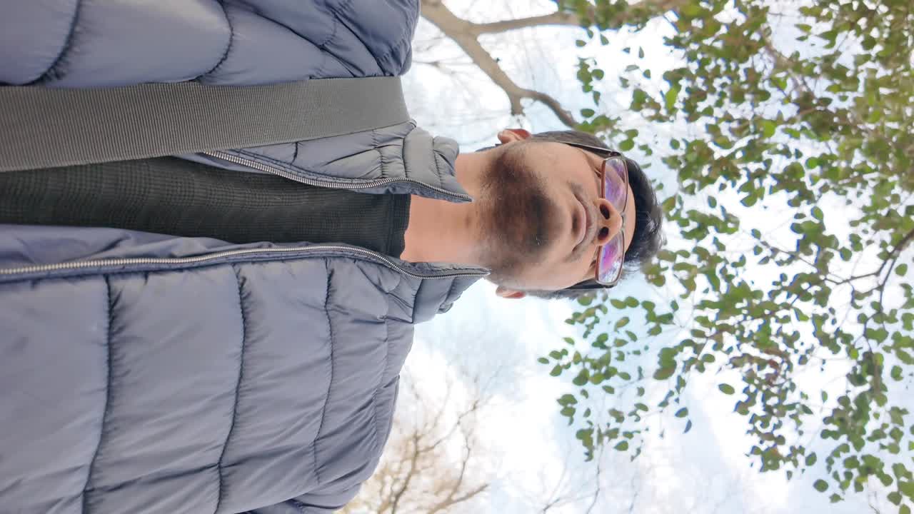 Man in jacket under trees