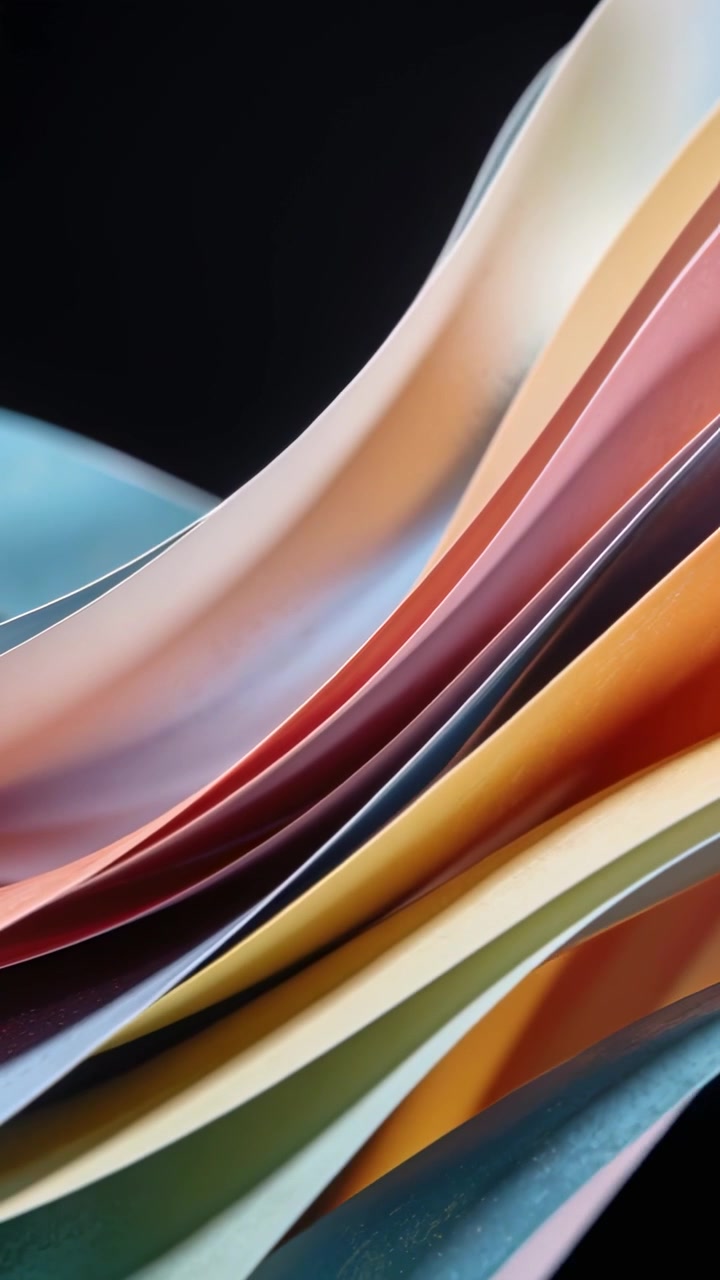 Vertical video: Panning camera revealing colored paper stack on desk, dark backdrop and lit edges