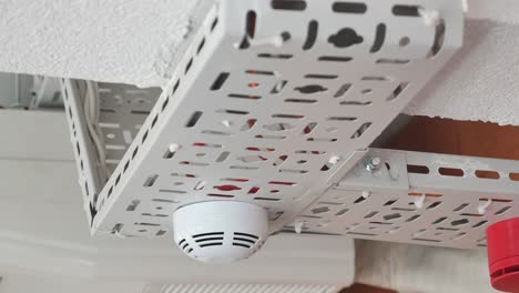 smoke detector and cable trays on a ceiling