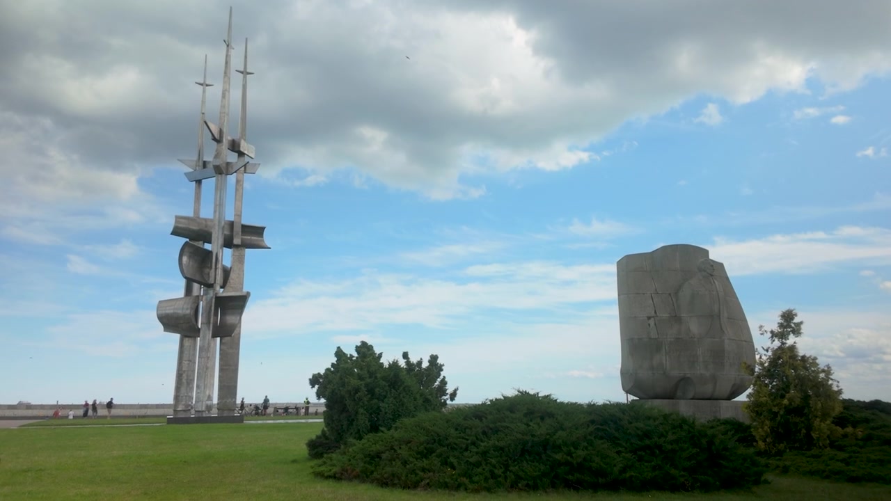Eine Weitwinkelaufnahme der ikonischen Metallskulptur an der Küstenpromenade von Gdynia, die moderne Architektur und urbanen öffentlichen Raum in Polen zeigt